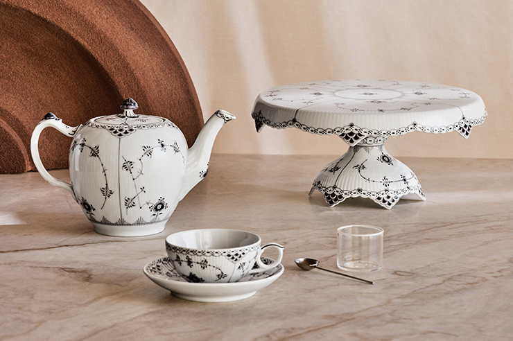 A Cake stand, a Teapot and a cup and saucer from the Black Fluted Half Lace collection from Royal Copenhagen